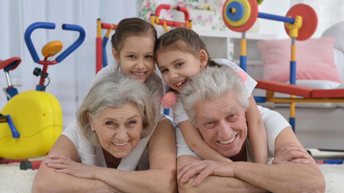 grandparents-little-granddaughters-doing-exercise-home_50612400