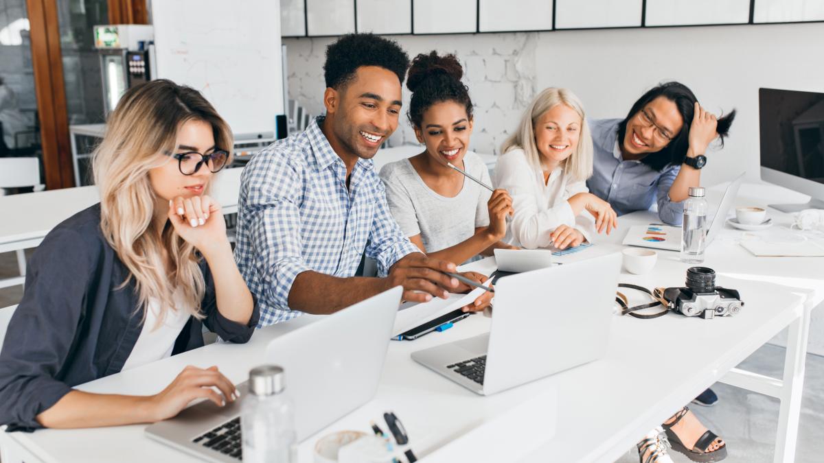 smiling-african-student-pointing-with-pencil-laptop-screen-concentrated-blonde-woman-glasses-propping-chin-with-hand-while-working-with-computer-office_95444400