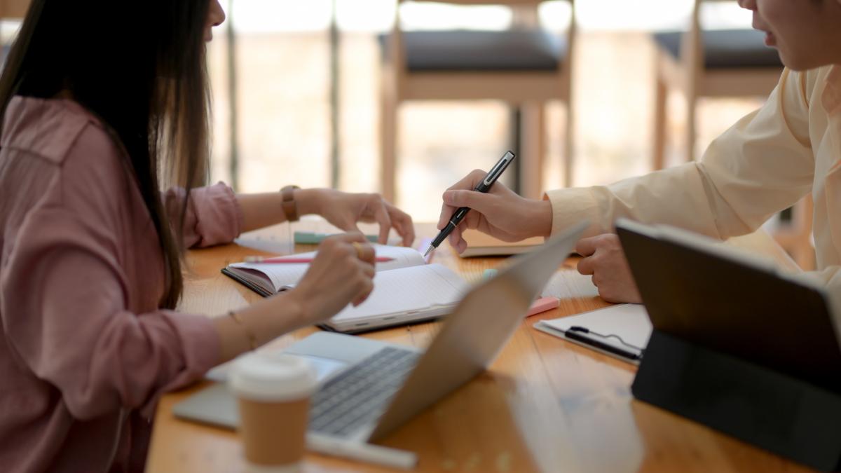 cropped-shot-university-students-sitting-coffee-shop-reading-together_55567100