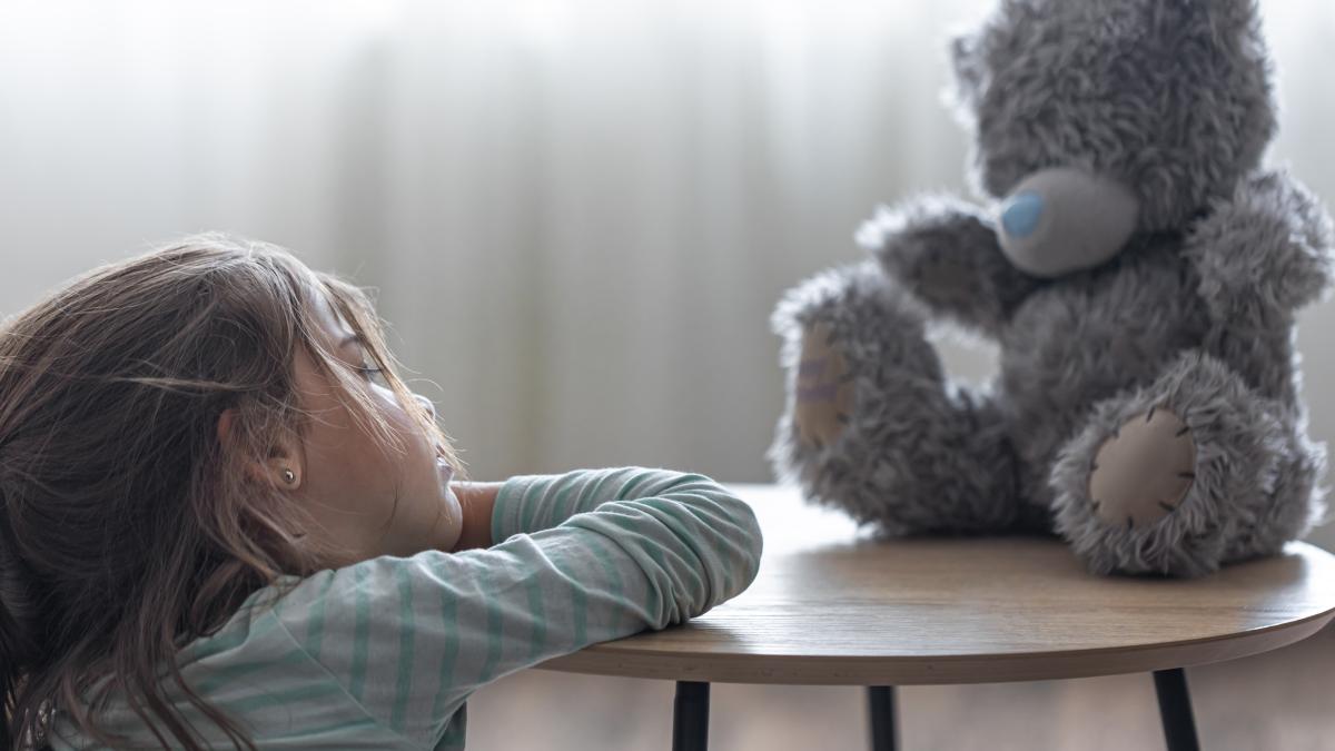 little-girl-looks-her-teddy-bear-child-with-favorite-toy-blurred-background-copy-space_03596400
