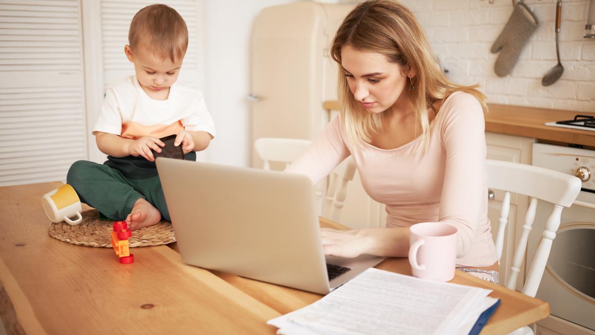 worried-upset-young-blonde-female-sitting-kitchen-table-with-papers-portable-computer-feeling-stressed-because-she-has-make-report-take-care-her-baby-son-while-he-is-staying-home_07685200