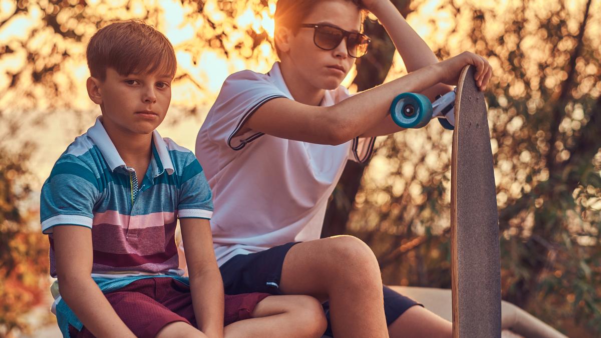 portrait-two-little-brothers-with-skateboard-sitting-stone-guardrail-outdoors-sunset_62826100