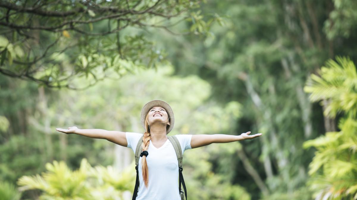 young-happy-woman-with-backpack-raising-hand-enjoy-with-nature_74971100