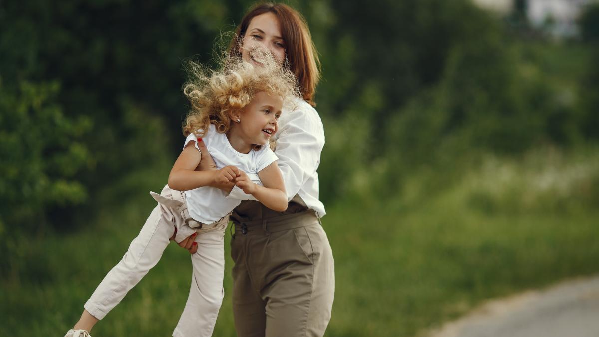 mother-with-daughter-playing-summer-field_56953300