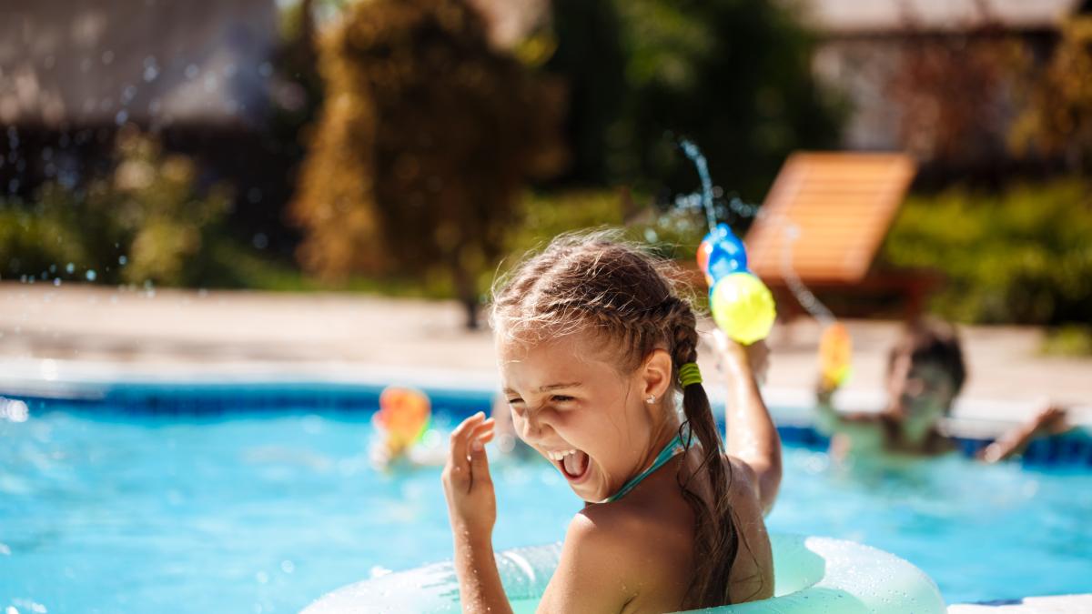 cheerful-children-playing-waterguns-rejoicing-jumping-swimming-pool_82683800