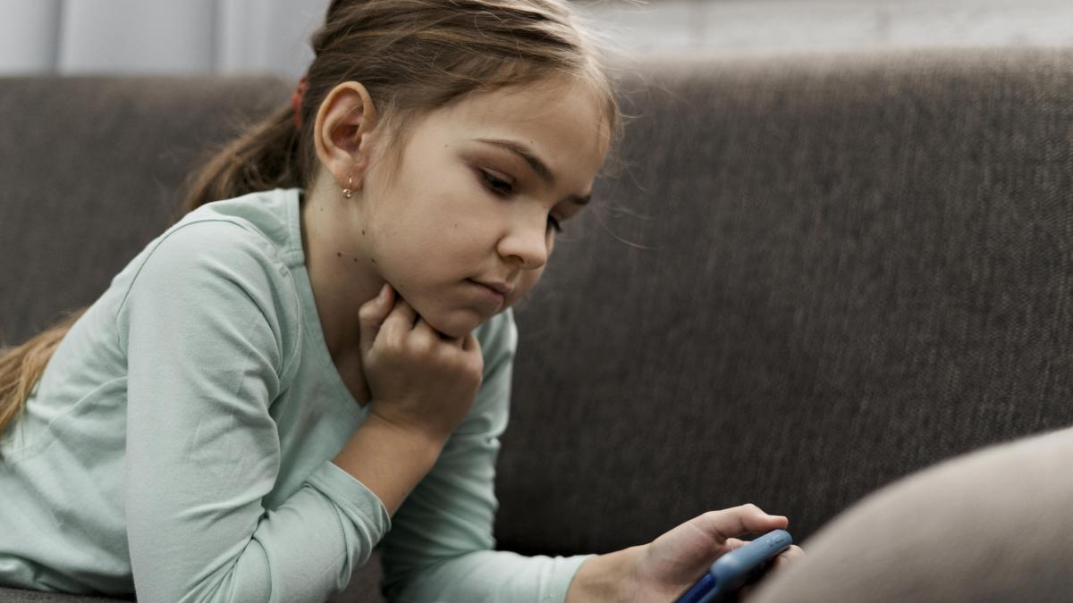 little-girl-playing-smartphone-home_89963100