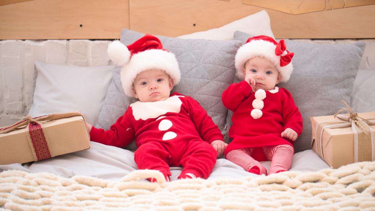 twins-new-year-s-costumes-laying-bed-smiling-rejoicing_44591700