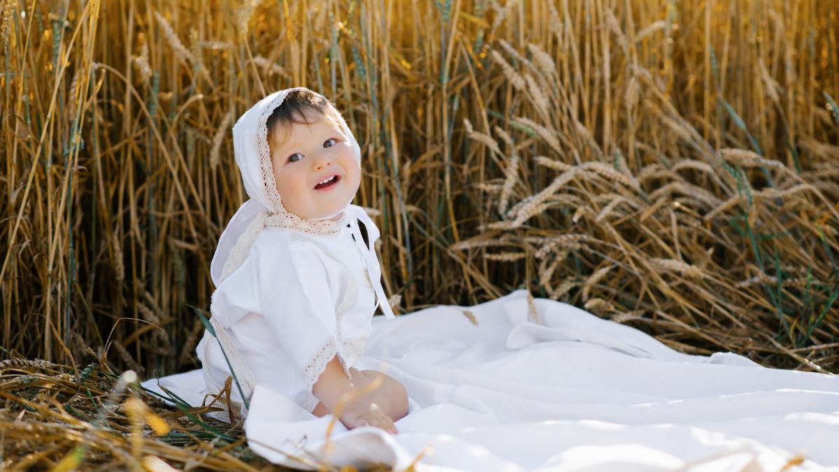 sweet-eight-month-old-baby-boy-sitting-blanket-field-laughing_60434300