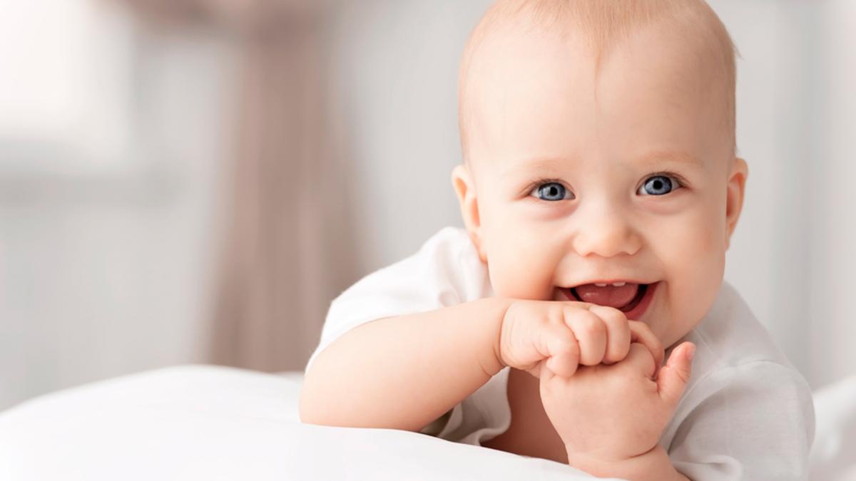 baby-is-smiling-has-his-hands-his-chin_72671000