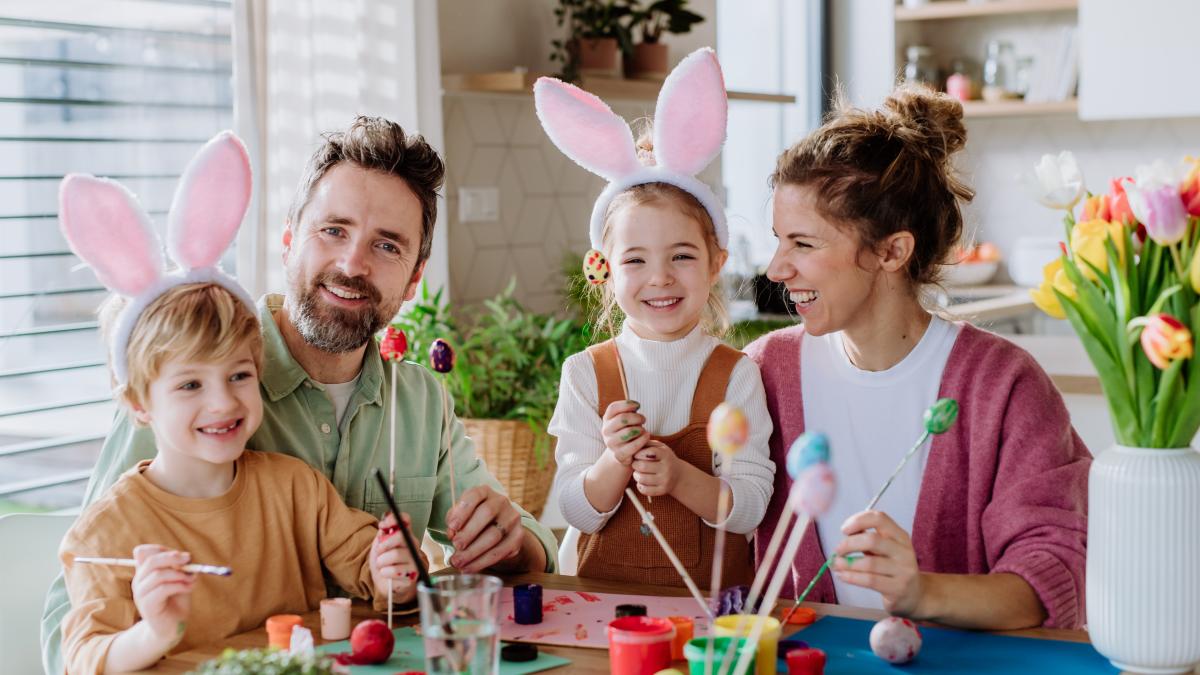 happy-family-with-little-kids-decorating-easter-eggs_89817200