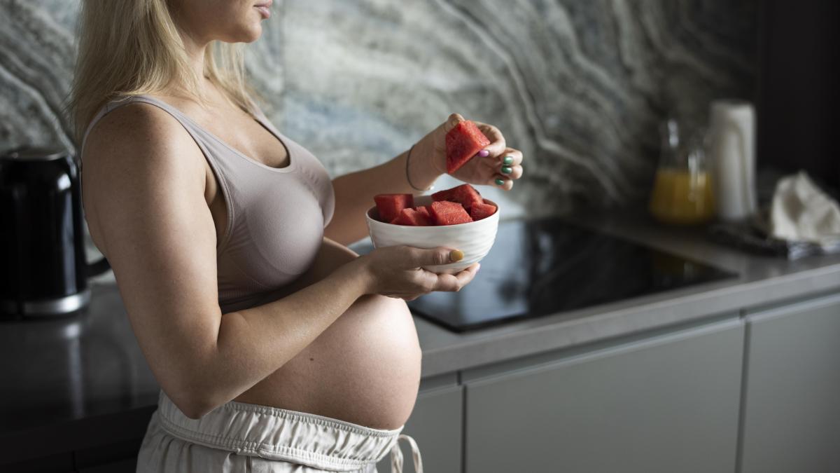 close-up-pregnant-woman-holding-fruit-bowl_84383600