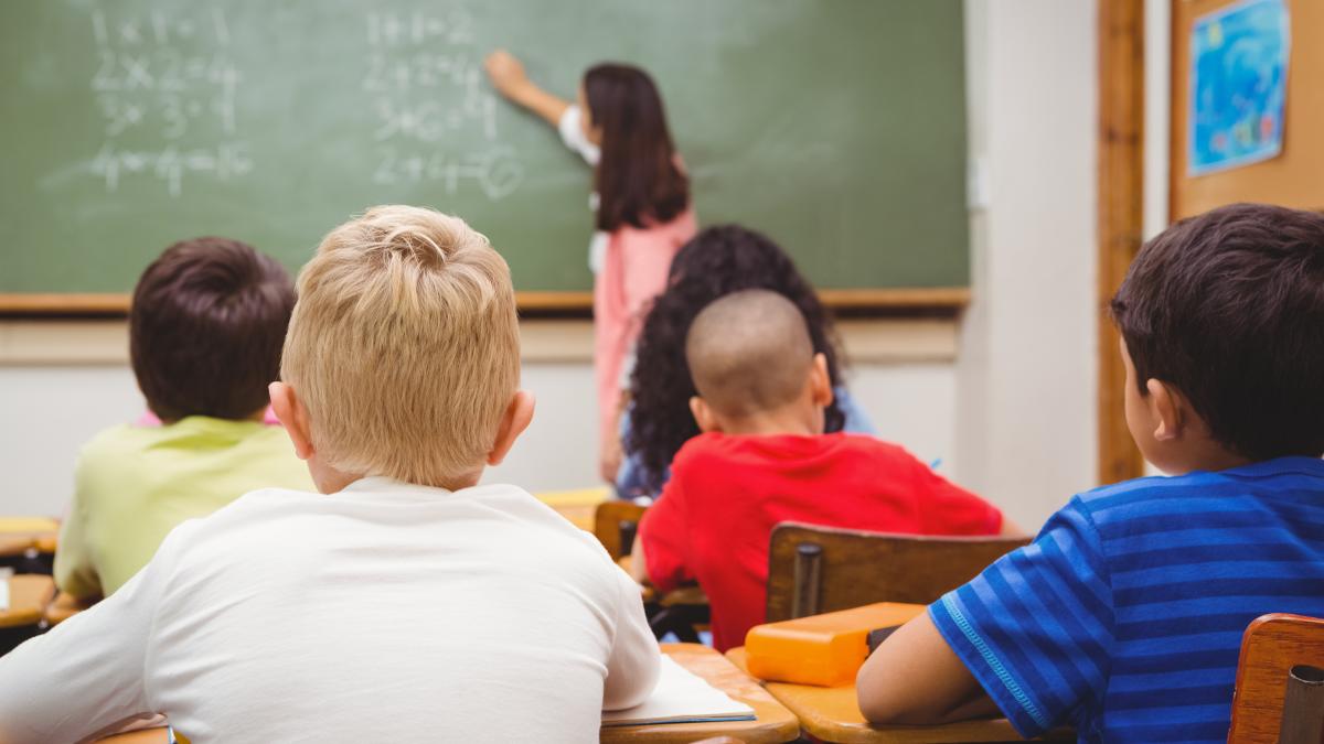 elevi-in-banci-in-clasa-profesoara-scrie-pe-tabla