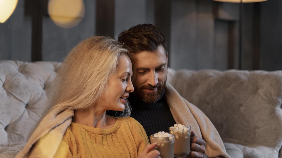 cuplu bând ciocolată cașdă în pat