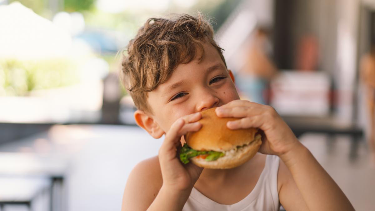 copil care mănâncă fast food
