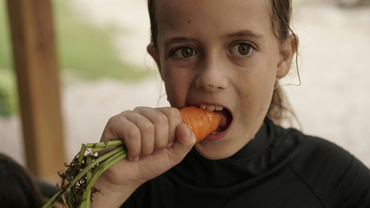 fetiță mâncând morcov