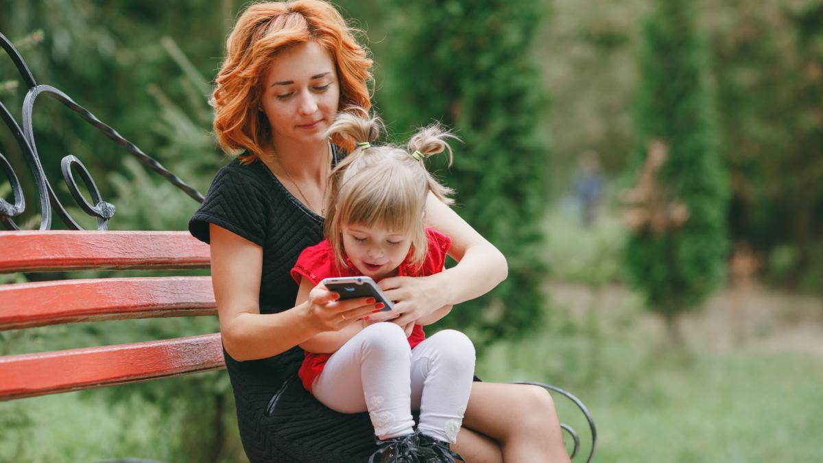 mama și copilul pe telefon în parc