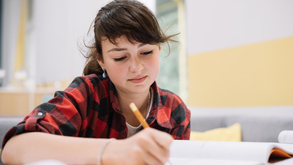 fată care scrie în caiet
