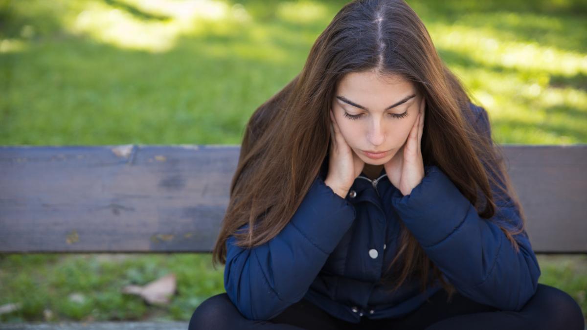 pensive-pretty-woman-sitting-bench-park