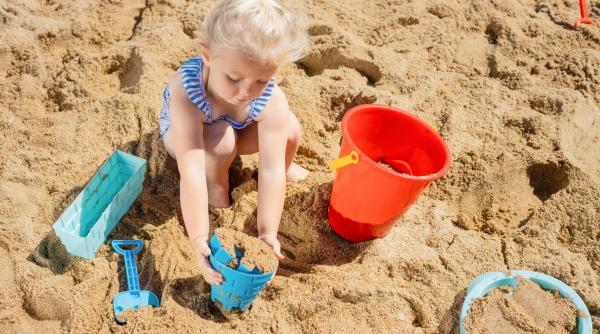 Ce să faci dacă copilul mănâncă nisip la plajă?